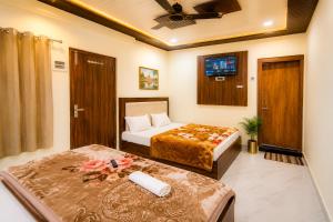 a hotel room with two beds and a tv at Hotel Diamond inn Mathura in Mathura +6 photos