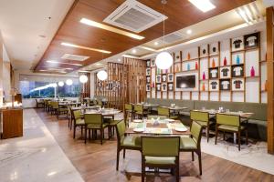 a restaurant with tables and chairs in a room at Lemon Tree Hotel, Sector 60, Gurugram in Gurgaon