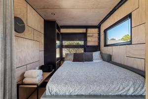 a bed in a small room with a window at Trackside Tiny Home in Augusta