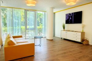 a living room with a couch and a tv at Gästehaus Gothensee in Heringsdorf