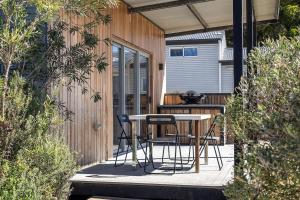 a patio with a table and chairs on a deck at Trackside Tiny Home in Augusta +5 photos