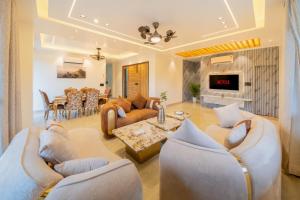 a living room with couches and a dining room at Water by The StayCationer in Dehradun