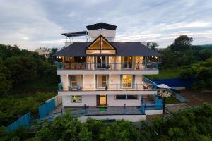 a large white house with a black roof at Water by The StayCationer in Dehradun