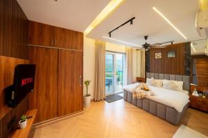 a bedroom with a large bed and a large window at Water by The StayCationer in Dehradun +33 photos