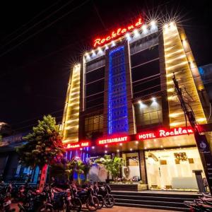 a hotel with a neon sign in front of it at Hotel Rockland Kota in Kota