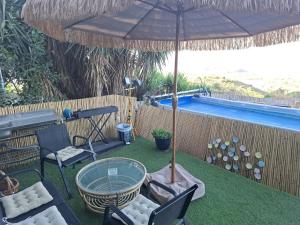 a table and chairs under an umbrella next to a pool at צימר תומר דבורה-קצה ההר in Kerem Ben Zimra +23 photos