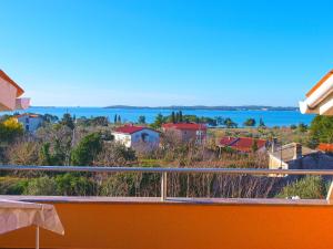 uitzicht op het water vanaf het balkon van een huis bij Apartments Orange 994 in Fažana
