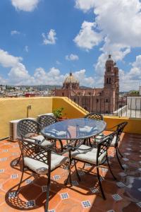 a table and chairs on a balcony with a view of a building at Hotel Casa Santa Lucia in Zacatecas