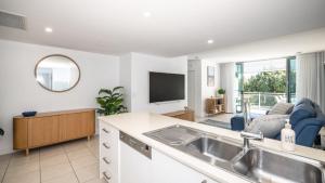 a kitchen with a sink and a living room at Whispering Waves On Boyd in Woorim +16 photos