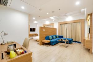a hotel room with a blue couch and a bed at Lemon Tree Hotel, Sector 60, Gurugram in Gurgaon