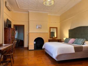 a bedroom with a bed and a fireplace at Oakdene Guest House in Oudtshoorn