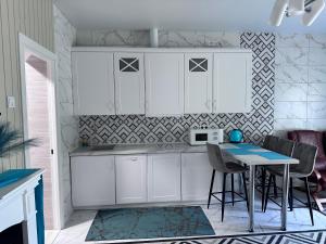 a kitchen with white cabinets and a table with chairs at Stop Time in Slavske
