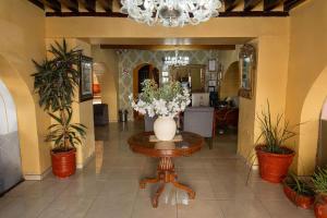 a vase of flowers on a table in a hallway at Hotel Casa Santa Lucia in Zacatecas