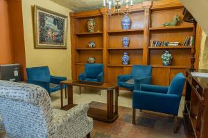 a living room with blue chairs and a table at Hotel Casa Santa Lucia in Zacatecas