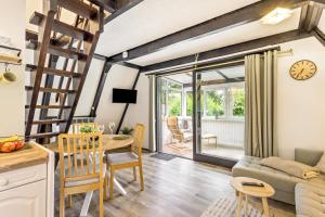 a kitchen and living room with a table and a couch at Tiny House Trudi mit Garten in Bad Wünnenberg
