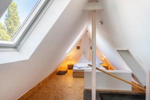 a attic bedroom with a bed and a window at Ferienwohnung Glück In Dornum in Dornum