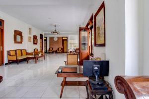 a living room with a tv on a table at Hotel O near Alun-Alun Kidul formerly Ndalem Mantrijeron Hotel in Yogyakarta
