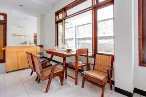 a dining room with a wooden table and chairs at Hotel O near Alun-Alun Kidul formerly Ndalem Mantrijeron Hotel in Yogyakarta