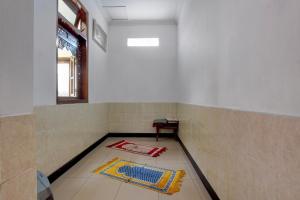 a room with a tile floor with a rug on the floor at Hotel O near Alun-Alun Kidul formerly Ndalem Mantrijeron Hotel in Yogyakarta +46 photos