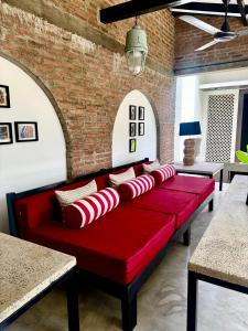 a red couch in a room with a brick wall at Palace Bope Galle in Galle