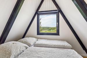a bed in a room with a window at Tiny House Trudi mit Garten in Bad Wünnenberg