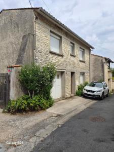 a white car parked in front of a brick house at maison village in Xambes