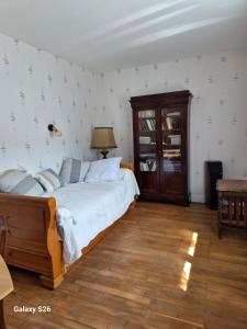 a bedroom with a large bed and a wooden floor at maison village in Xambes