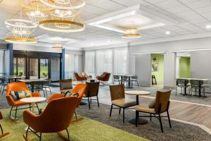 a waiting room with tables and chairs and tablesktop at Spark By Hilton Akron Fairlawn in Fairlawn