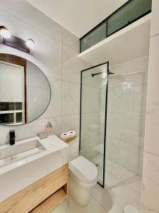 a bathroom with a toilet and a sink and a mirror at CasaLoop in Ica