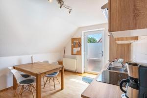 a kitchen and dining room with a wooden table and chairs at Ferienwohnung Glück In Dornum in Dornum