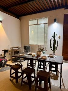 a dining room with a table and chairs and a cactus at CasaLoop in Ica