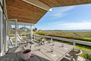 a patio with a table and chairs on a balcony at FJ1601-Jaegerspris-Strandleddet-25 in Jægerspris