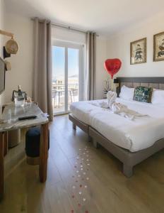 a bedroom with two beds and a table and a window at Hôtel La Villa Cap d’Antibes in Juan-les-Pins +77 photos