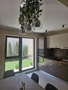 a kitchen with a table and a large window at VILA MRV in Constanţa