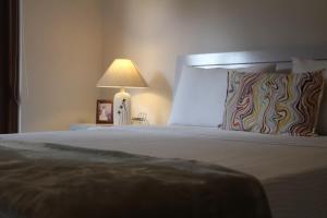 a bedroom with a bed with a lamp on a table at Kavis Home in Ekalakurunduwatta
