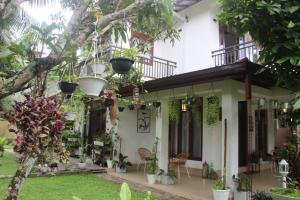 a house with a lot of plants in the yard at Kavis Home in Ekalakurunduwatta