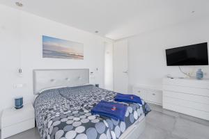 a bedroom with a bed and a flat screen tv at Son Serra Relax 2 By homevillas360 in Son Serra de Marina +20 photos