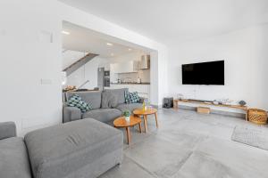 a living room with a couch and a tv at Son Serra Relax 2 By homevillas360 in Son Serra de Marina