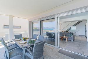 a dining room and living room with a table and chairs at Son Serra Relax 2 By homevillas360 in Son Serra de Marina