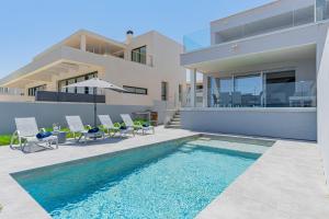 a house with a swimming pool in front of a house at Son Serra Relax 2 By homevillas360 in Son Serra de Marina
