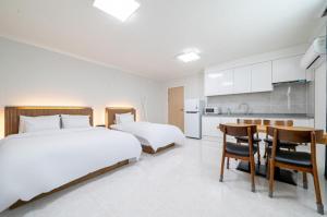a bedroom with two beds and a table and a kitchen at Y2 Stay Hotel in Sokcho