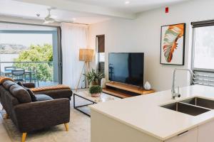 a living room with a tv and a couch and a kitchen at 201 - Ocean Views Oceanfront Large Balcony in Suva
