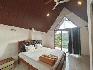 a bedroom with a large bed and a large window at Mermaid Avisa in Arambol