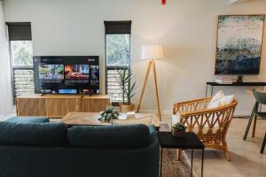 a living room with a blue couch and a tv at 202 - Ocean Views Oceanfront Large Balcony in Suva