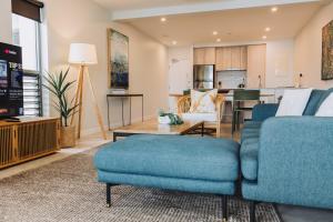 a living room with a blue couch and a table at 202 - Ocean Views Oceanfront Large Balcony in Suva