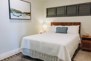 a bedroom with a white bed and a picture on the wall at 202 - Ocean Views Oceanfront Large Balcony in Suva