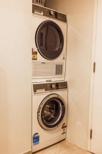 a microwave and a washer and dryer in a room at 307 - Suva City Views Oceanfront Large Balcony in Suva