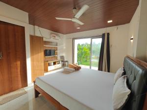 a bedroom with a bed and a large window at Mermaid Avisa in Arambol