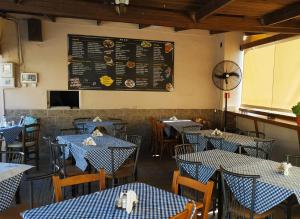 a restaurant with blue and white tables and a chalkboard at Blue Marianthi in Ávdhira