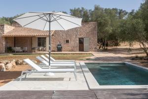 a pool with two lounge chairs and an umbrella at Villa Biniali Costitx in Costitx